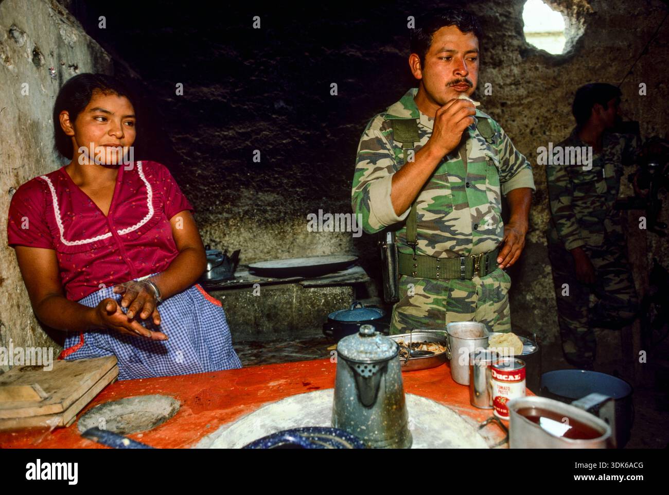 Guatemala, avril 1986 ; Un soldat mange dans la cuisine d'un villageois à Huehuetenango. L'armée guatémaltèque a lancé un programme militaire civil dans le but de donner à la population rurale son image désastreuse. Banque D'Images