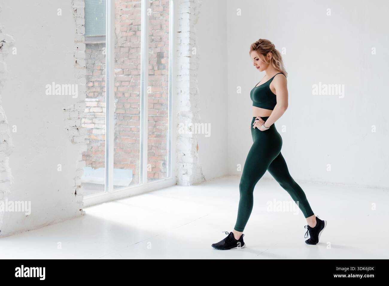 Femme active et confiante dans des vêtements de sport qui se posent sur l'appareil photo Banque D'Images