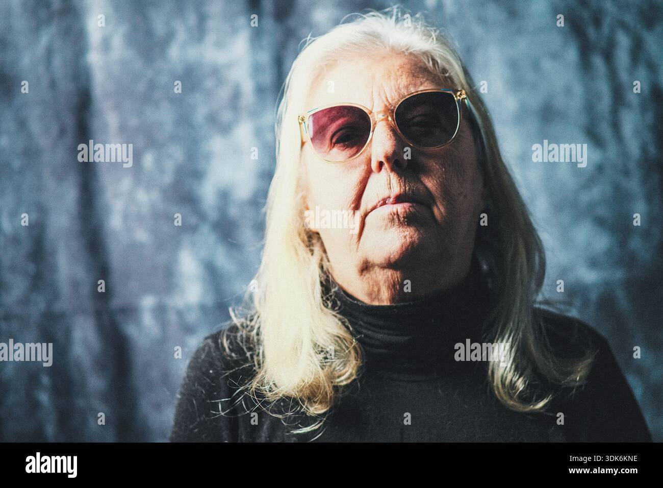 Portrait d'une femme caucasienne de soixante-dix ans portant des lunettes de soleil Banque D'Images