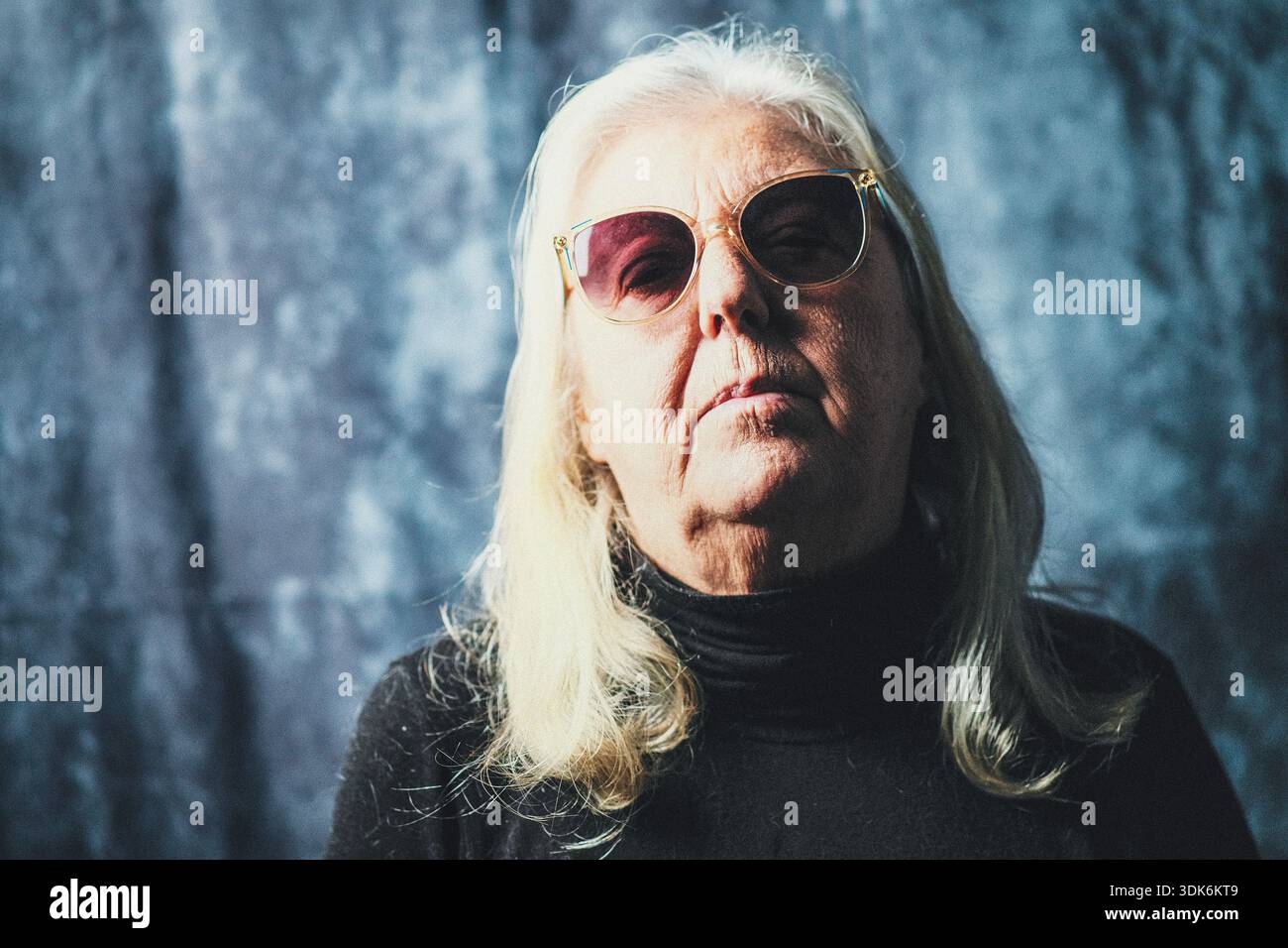 Portrait d'une femme caucasienne de soixante-dix ans portant des lunettes de soleil Banque D'Images