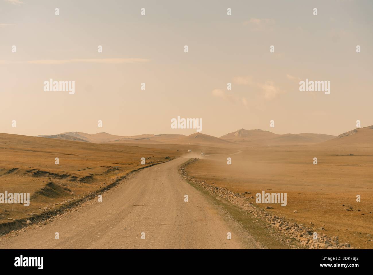 Un chemin de terre traversant un paysage aride et vallonné. Photo de haute qualité Banque D'Images