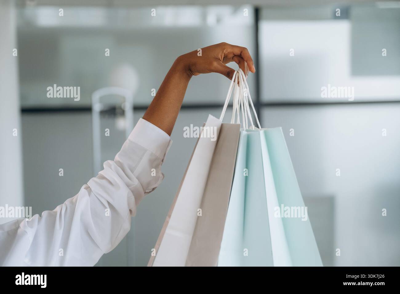 Vue rapprochée de la main de la femme qui tient des sacs à provisions à l'intérieur. Banque D'Images