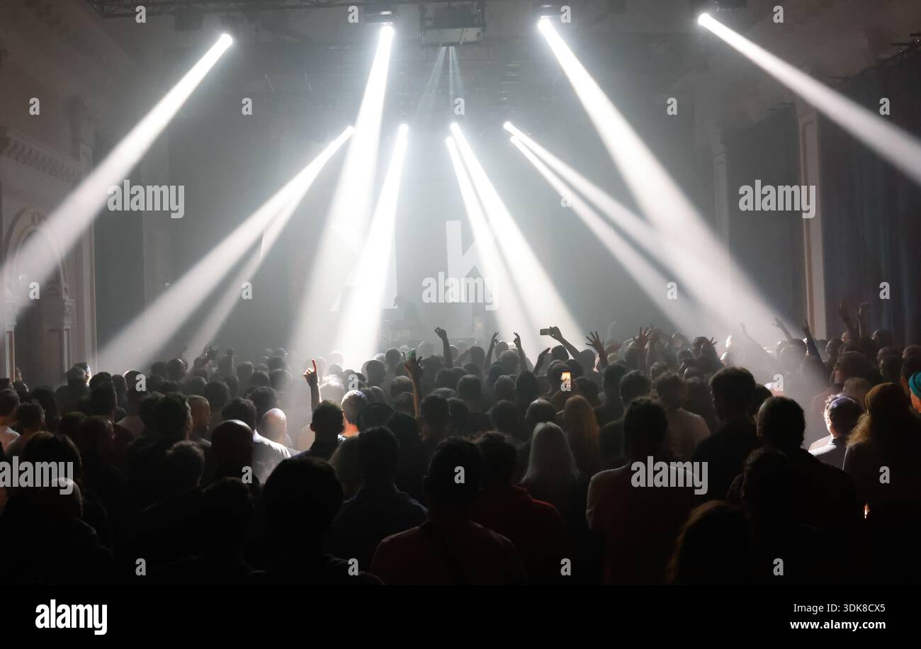 Événement musical live de l'artiste Clark avec des lumières blanches brillantes illuminant la scène et le public. Clark est un artiste électronique britannique bien connu. Banque D'Images