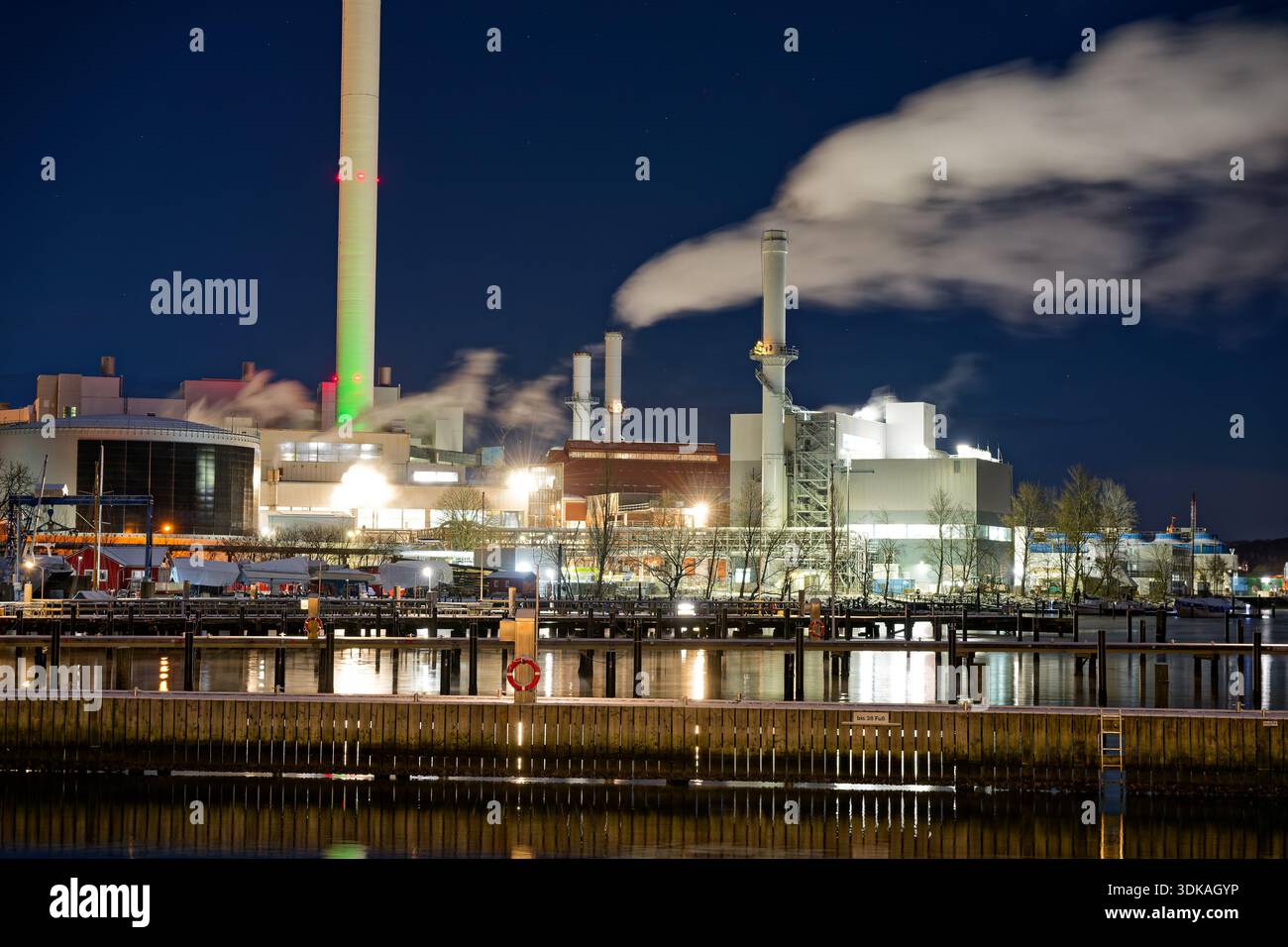 Centrale électrique illuminée de Stadtwerke Flensburg la nuit pendant le froid hivernal extrême en hiver 2025 2026 avec de la vapeur montant dans l'air glacial Banque D'Images