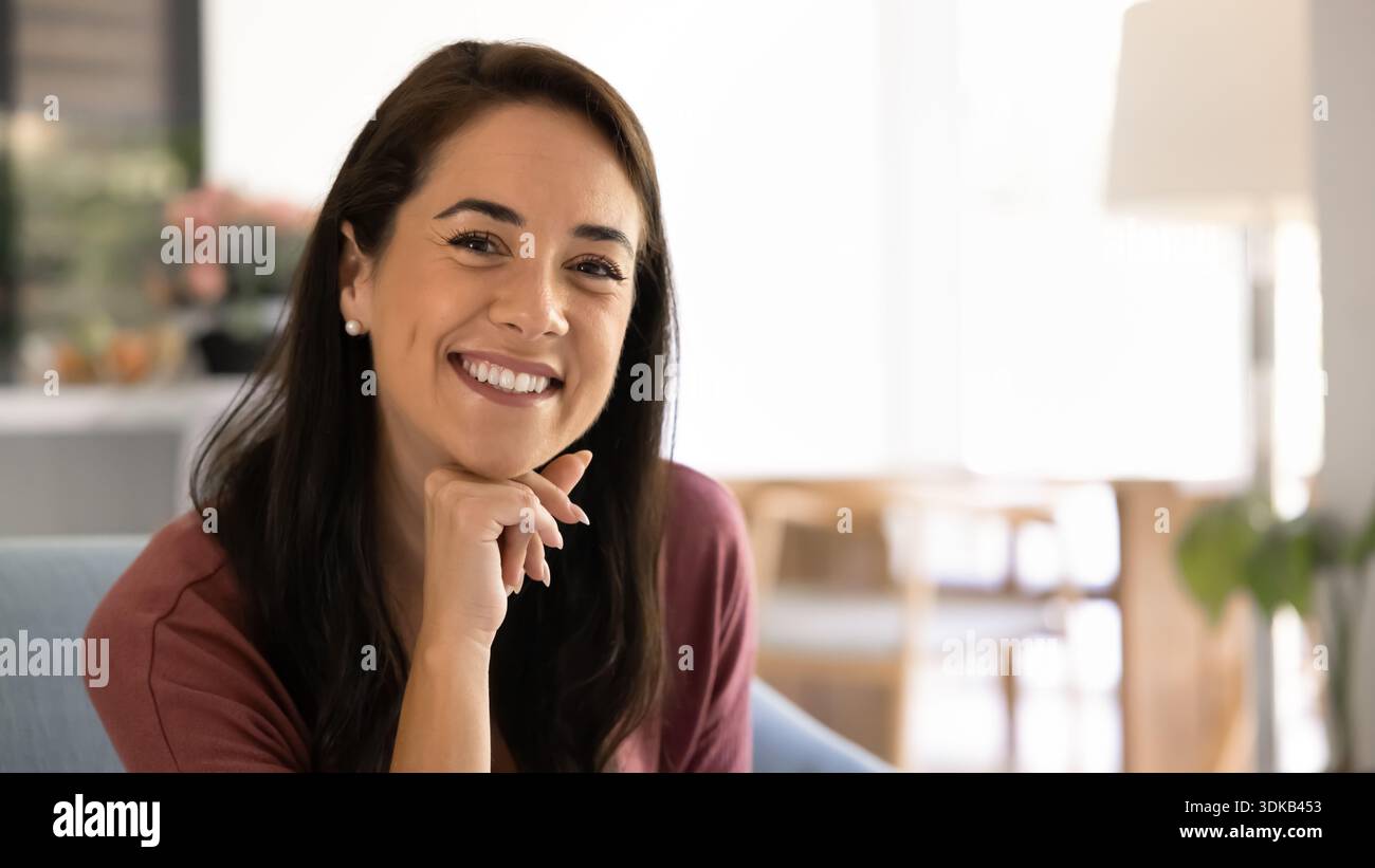 Portrait de femme heureuse assise sur un canapé dans le salon Banque D'Images