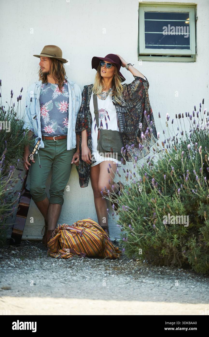 Mode, bohème ou couple au mur pour l'aventure, la confiance ou l'esthétique hippie en vacances. Style indépendant, homme ou femme en plein air avec des vêtements terreux Banque D'Images