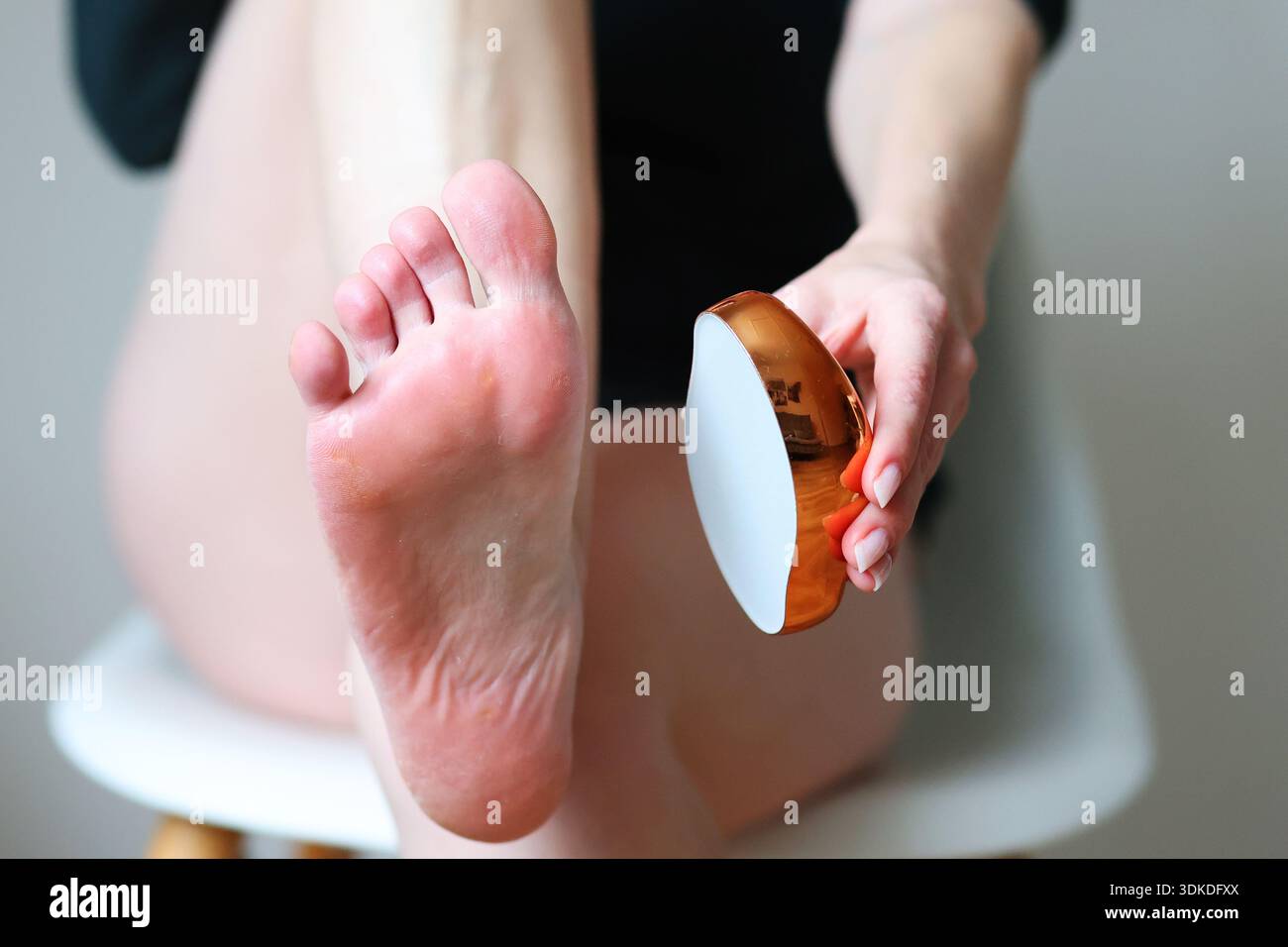 Exfoliation du pied féminin avec lime de pédicure en métal. Traitement de beauté, peau lisse et concept de soins personnels. Banque D'Images
