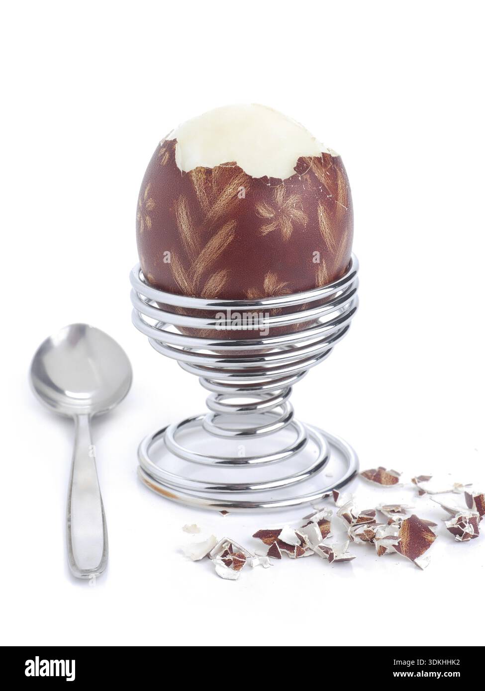 Oeufs à la coque avec des oeufs de Pâques ornement-shell dans un stand en spirale avec cuillère prêt pour le petit-déjeuner tourné sur fond blanc Banque D'Images