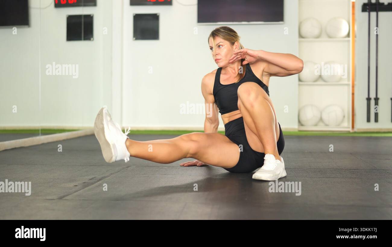 Femme exerçant la force de base faisant l'entraînement de fitness dans le gymnase Banque D'Images