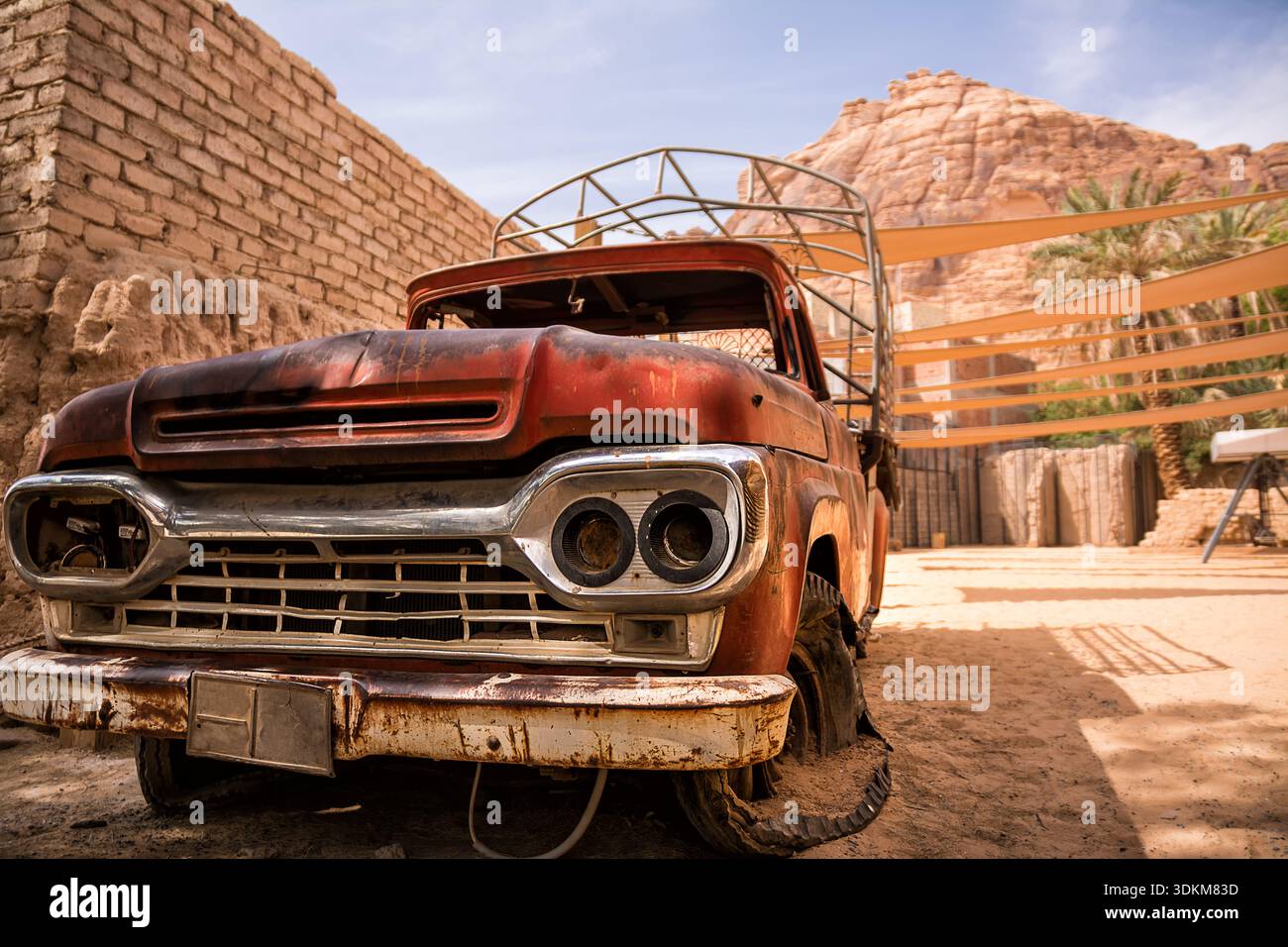 Vieux pick-up rouillé épave dans les rues étroites d'Al Ula Arabie Saoudite montrant la décomposition et les restes de véhicules vintage dans une ville historique du désert Banque D'Images