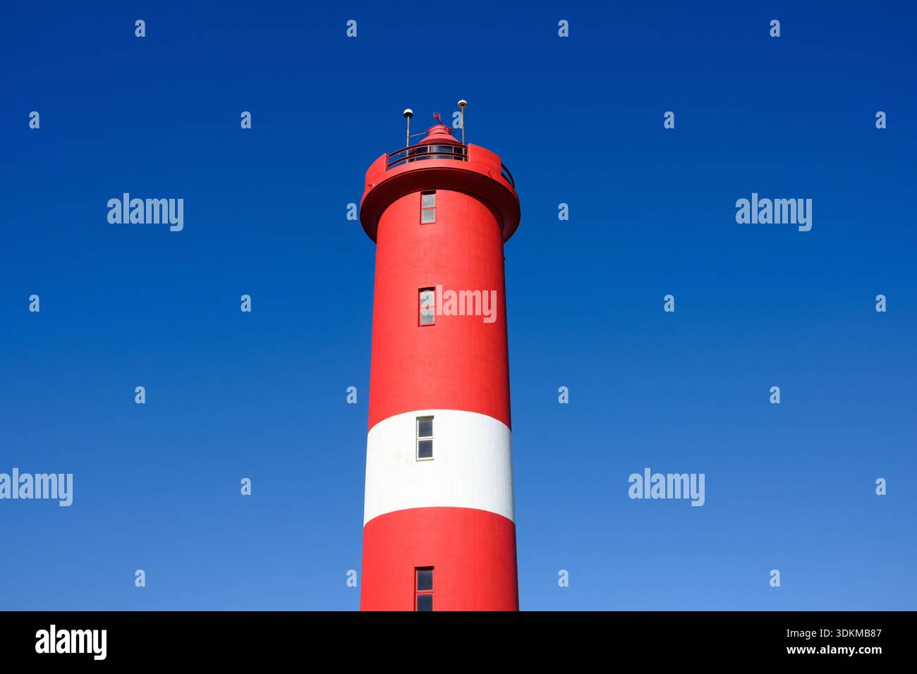 Phare rouge et blanc contre ciel bleu. Banque D'Images