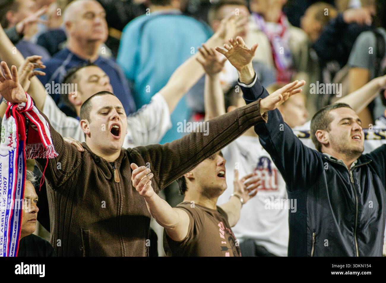 Les fans de football de Tottenham Hotspur encouragent passionnément, les bras levés, lors d'un match de Coupe de l'UEFA contre le Sevilla FC au stade Sánchez-Pizjuán, Séville, Espagne Banque D'Images