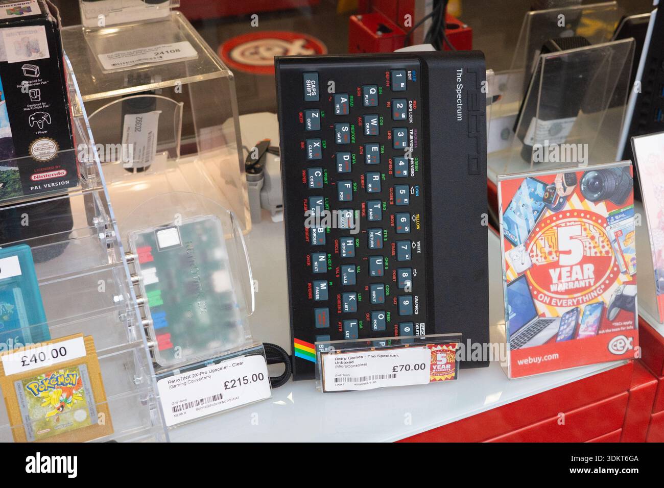 Newcastle upon Tyne UK : 17 novembre 2025 : une vitrine montre une sélection de cartouches de jeu rétro et d'accessoires dans un magasin CEX. Micro con. Spectre ZX Banque D'Images