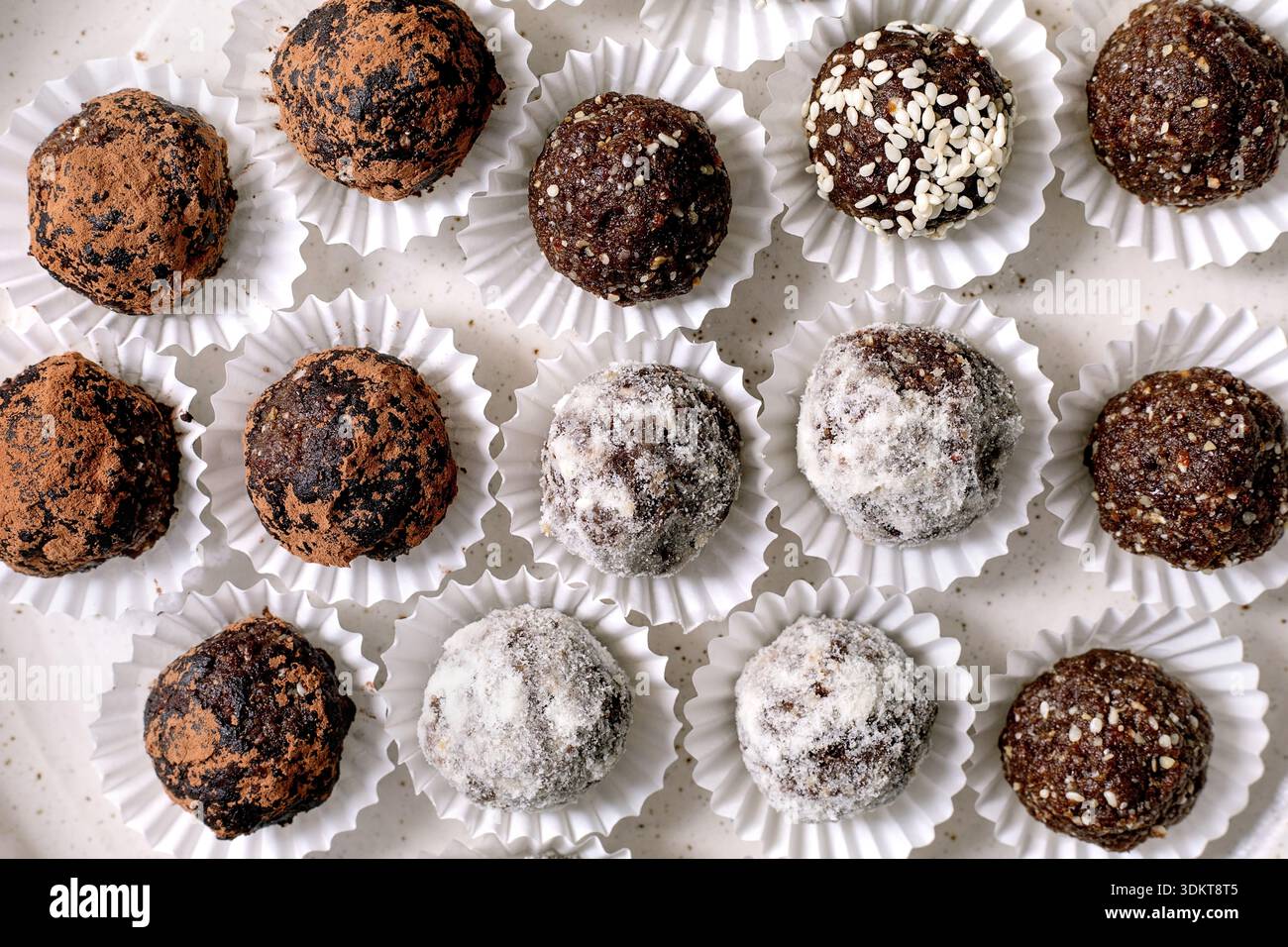 Variétés de boules végétaliennes brutes énergétiques saines faites maison avec des noix de graines de cacao. Différents enrobages, y compris la poudre de sucre graines de sésame poudre de cacao. Haut vi Banque D'Images
