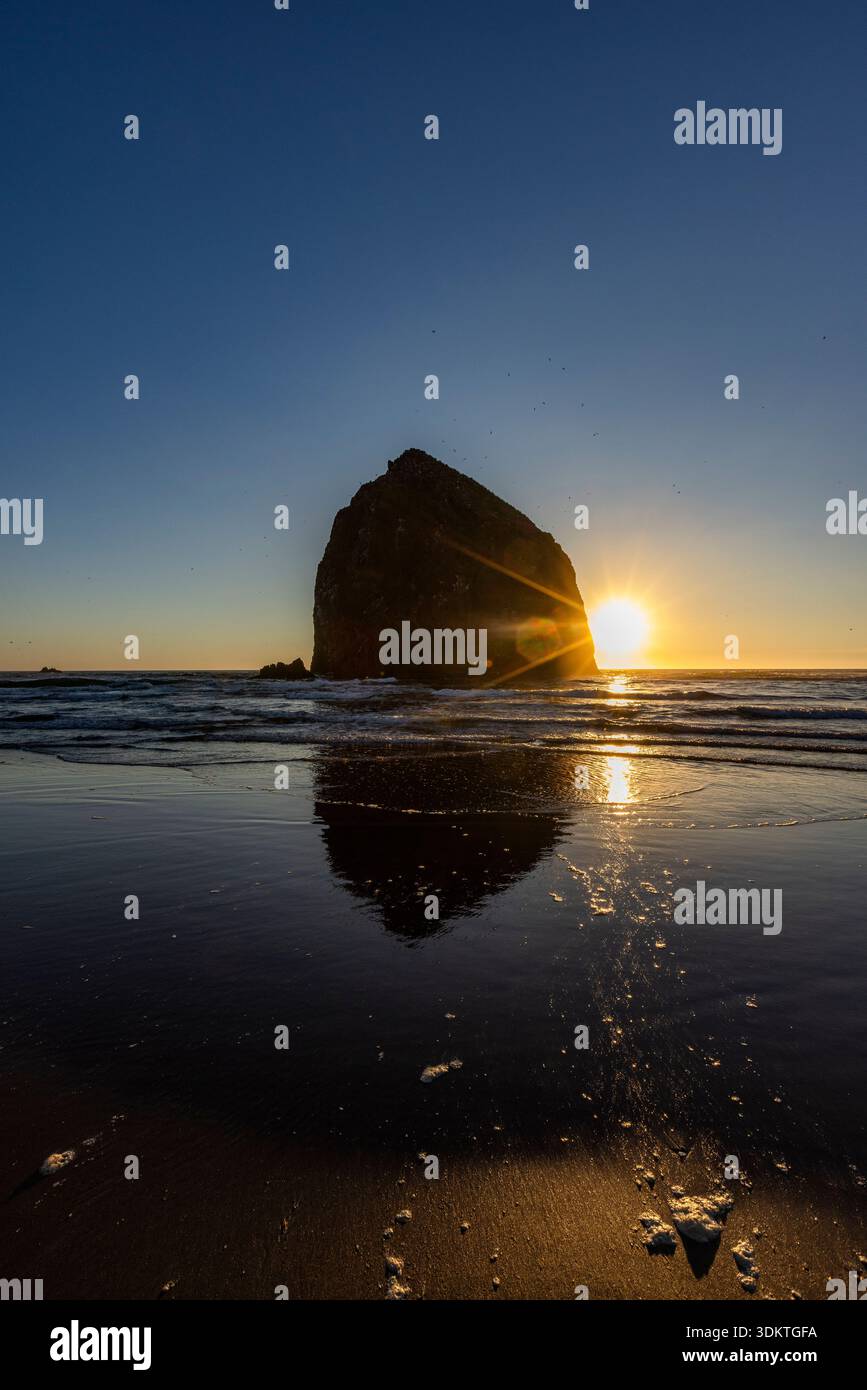 États-Unis, Oregon, coucher de soleil derrière le rocher de meule de foin sur Cannon Beach Banque D'Images