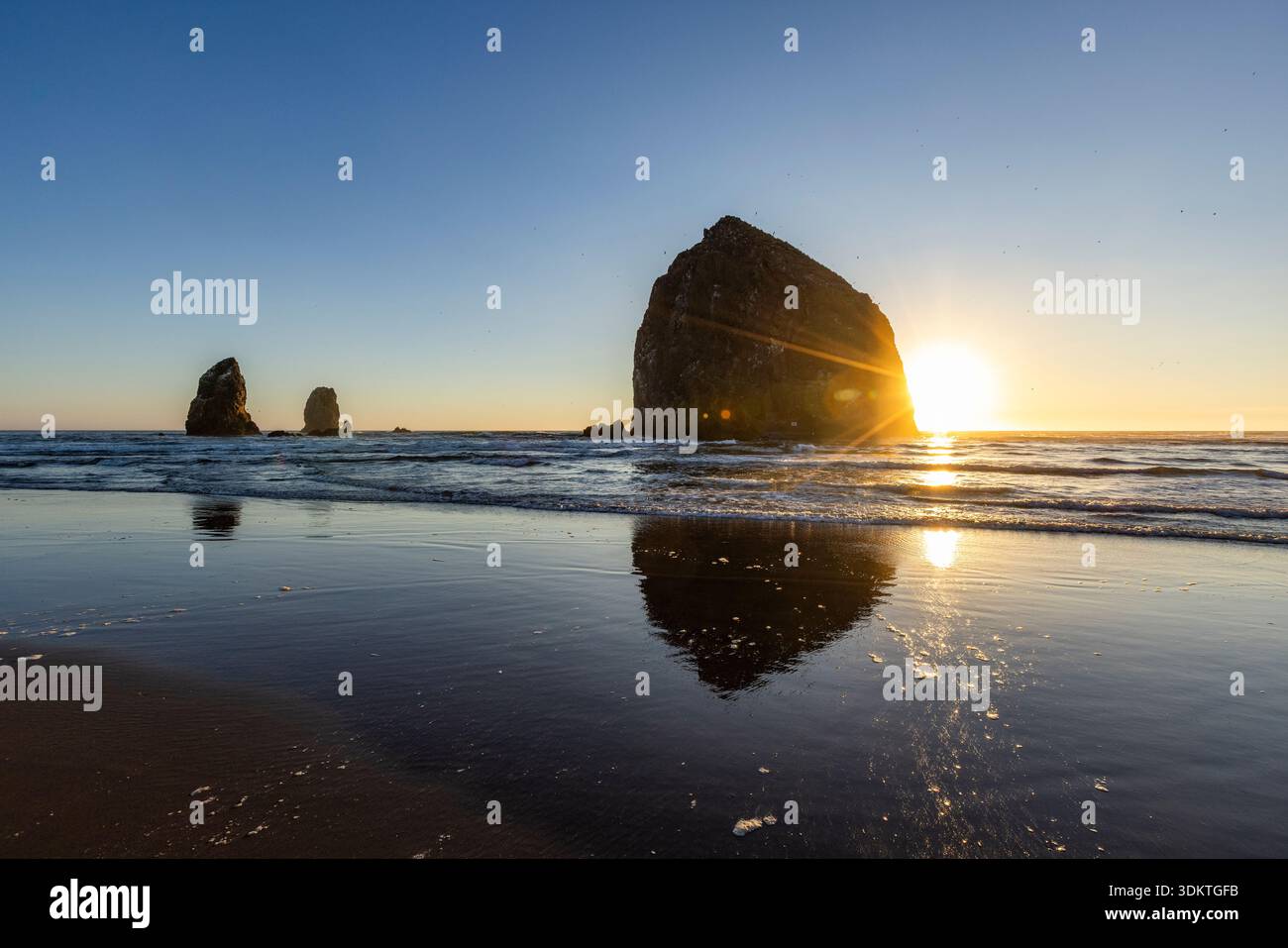 États-Unis, Oregon, coucher de soleil derrière le rocher de meule de foin sur Cannon Beach Banque D'Images