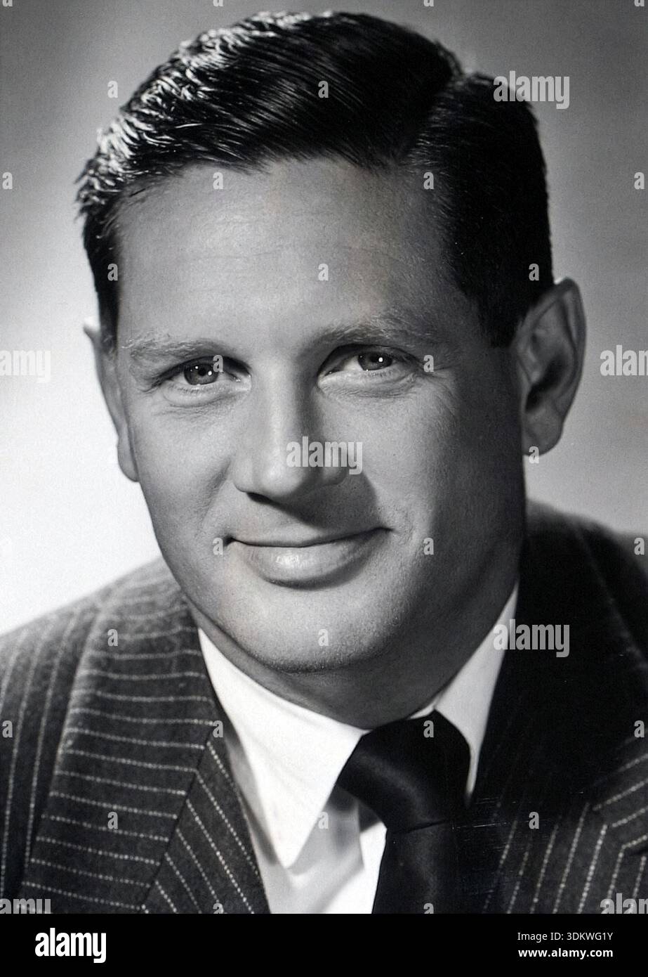 Cette photo publicitaire en noir et blanc de 1944 met en scène le scénariste et romancier américain Niven Busch, capturé avec un sourire subtil. Il est représenté dans un costume à fines rayures et une cravate, reflétant une esthétique professionnelle classique des années 1940 souvent vue dans la photographie en studio de l'époque. Banque D'Images