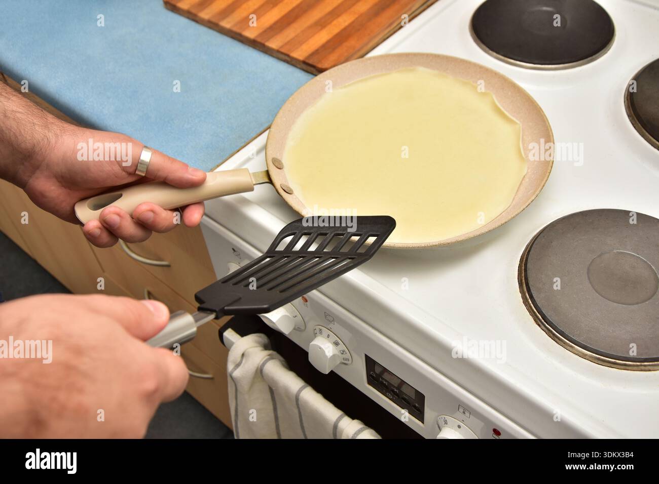 Gros plan mains masculines fabriquant des crêpes Banque D'Images