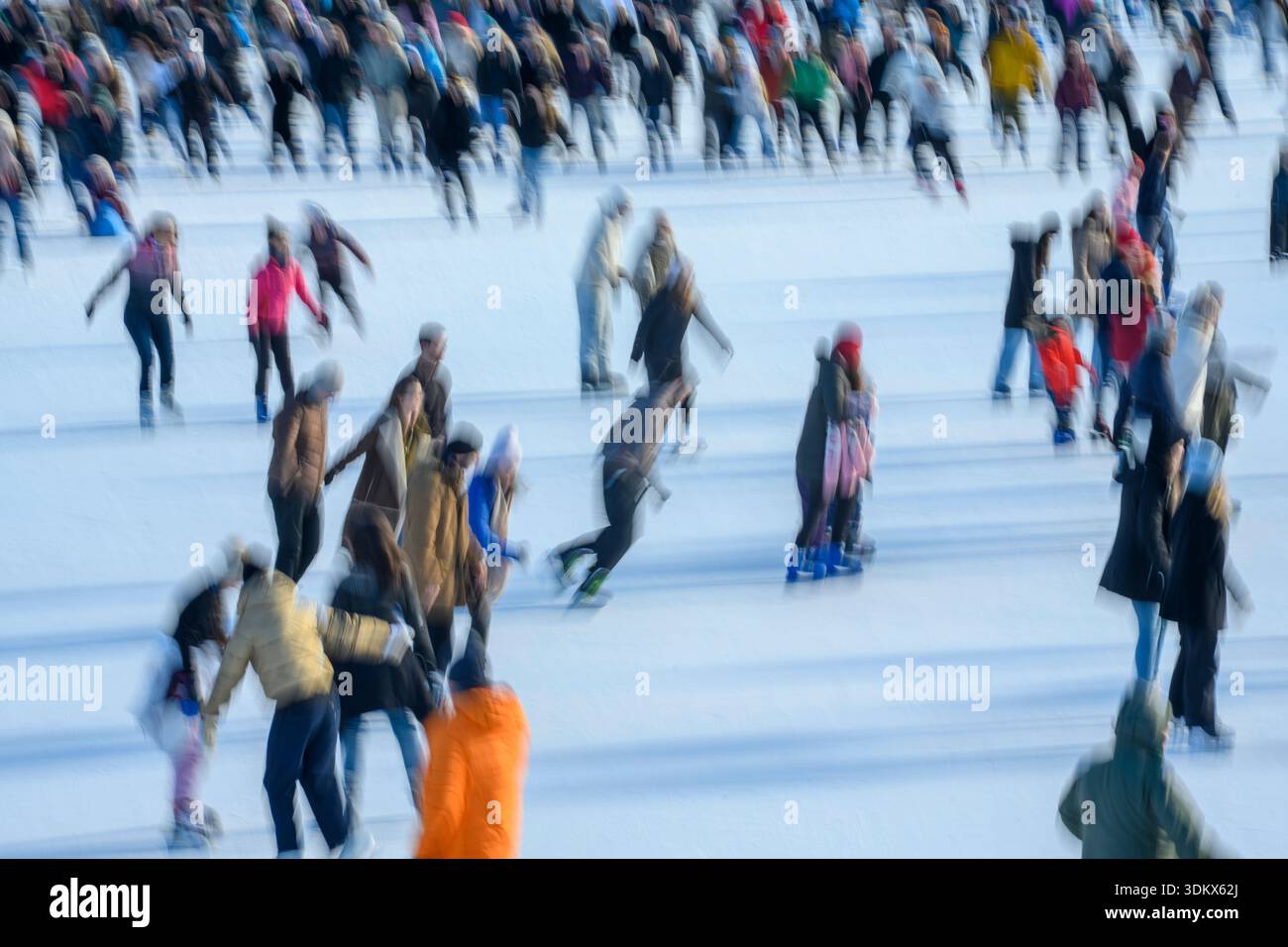 Budapest, Hongrie, grande foule de gens qui aiment le patinage sur glace et les sports d'hiver sur une patinoire extérieure pendant une journée ensoleillée. Avec un parc d'attractions featurin Banque D'Images