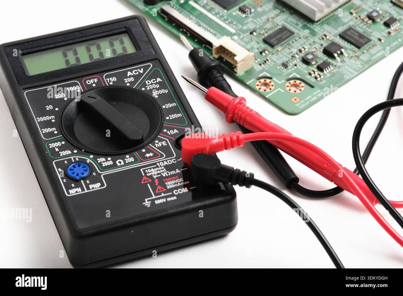 Vue en perspective d'un multimètre numérique à côté de la carte de circuit imprimé de l'ordinateur. Concept de dépannage et de maintenance du matériel électronique Banque D'Images