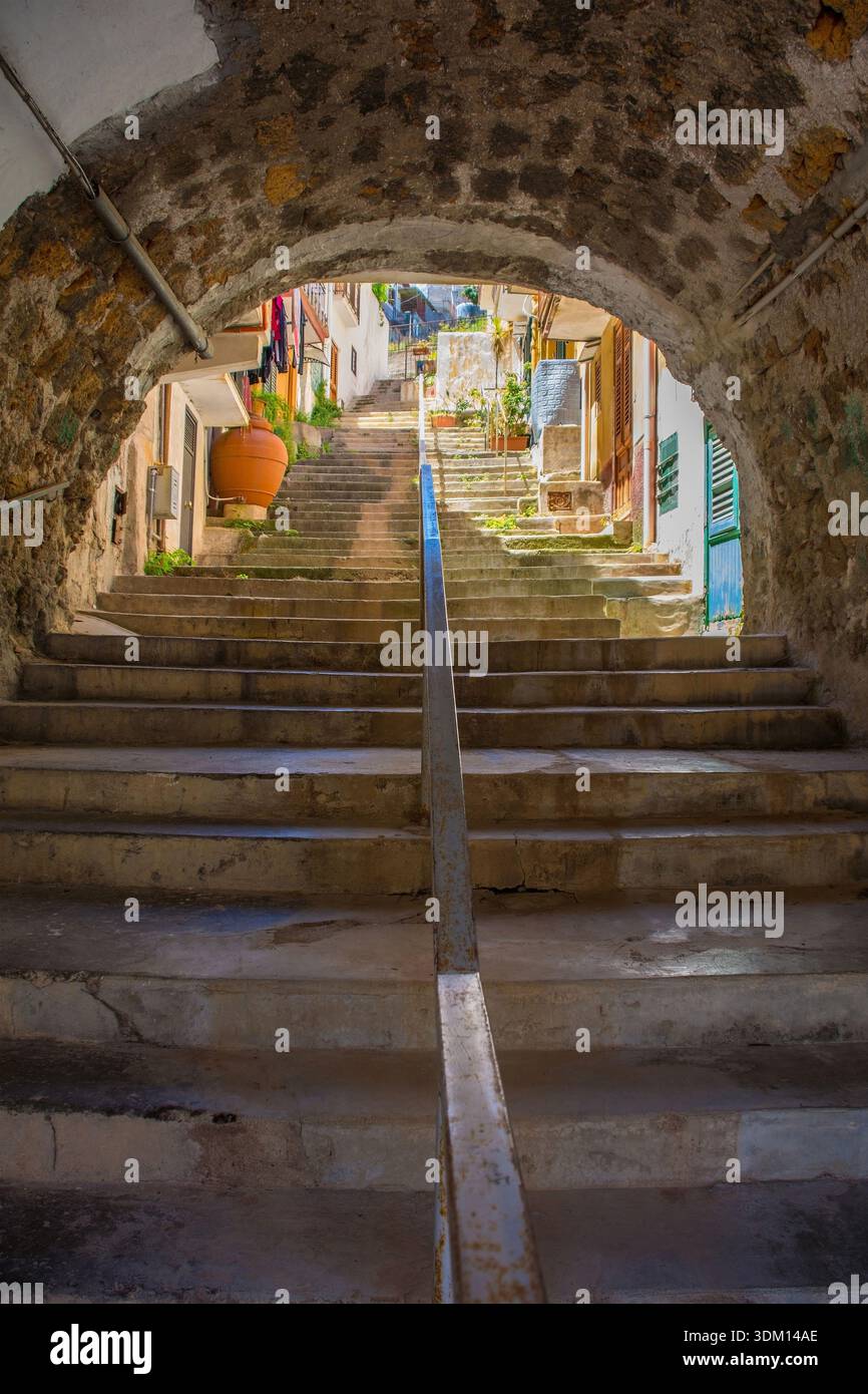 Une arche médiévale historique en pierre à Monreale, Sicile, Italie. Un passage du XIVe au XVIe siècle mène à une route plus élevée via un ensemble de marches bien usées. Banque D'Images