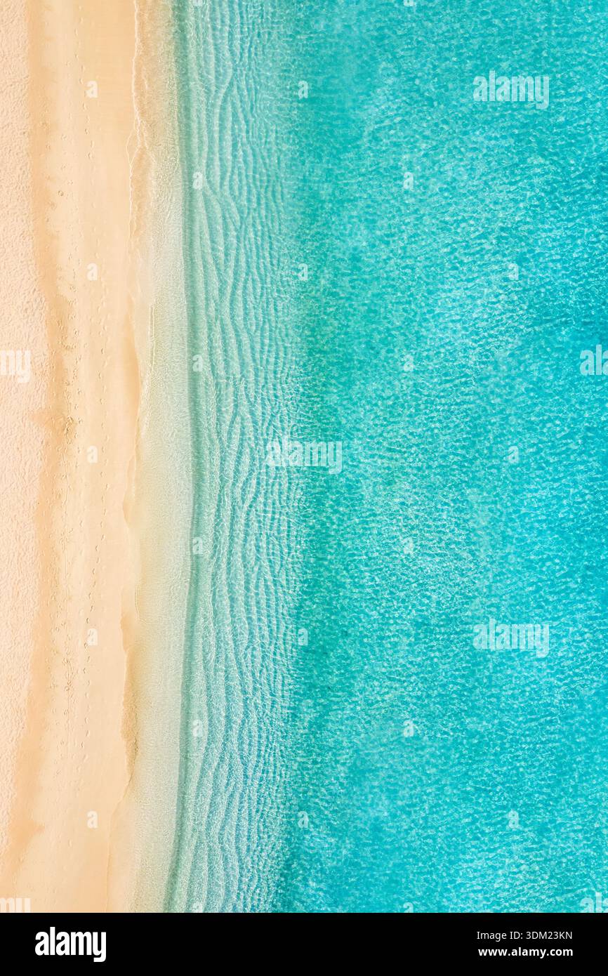 Dreamy Beach vertical aérien turquoise eau sable abstrait vue de dessus magnifique paradis destination côtière motif texture fond. Vagues océaniques Banque D'Images