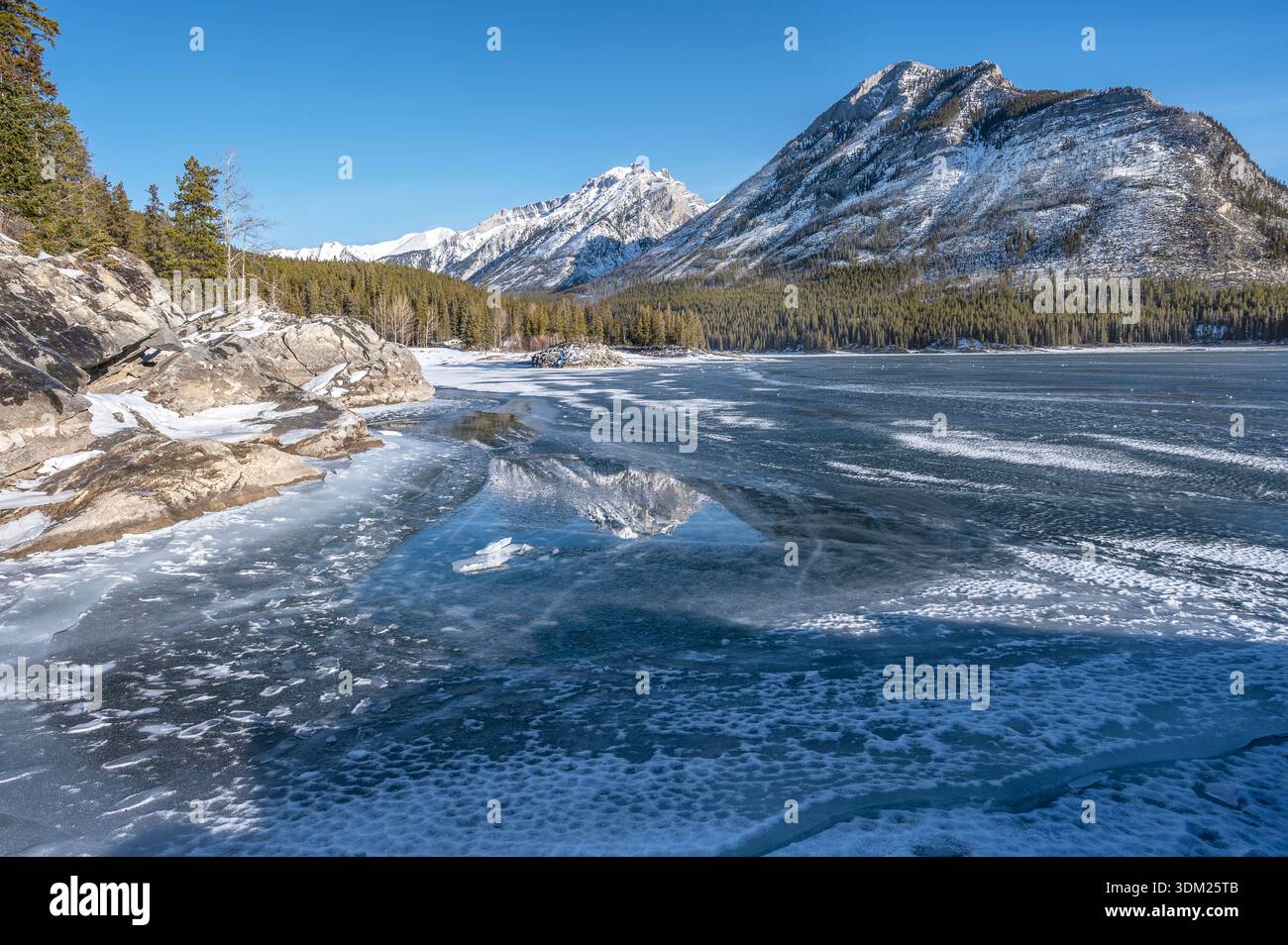 Réflexions dans le lac Minnewanka gelé, dans le parc national Banff, Alberta, Canada Banque D'Images