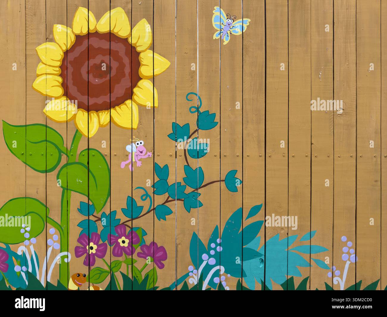 Une image de fond d'une clôture peinte d'un tournesol, de plantes colorées et d'insectes volants Banque D'Images