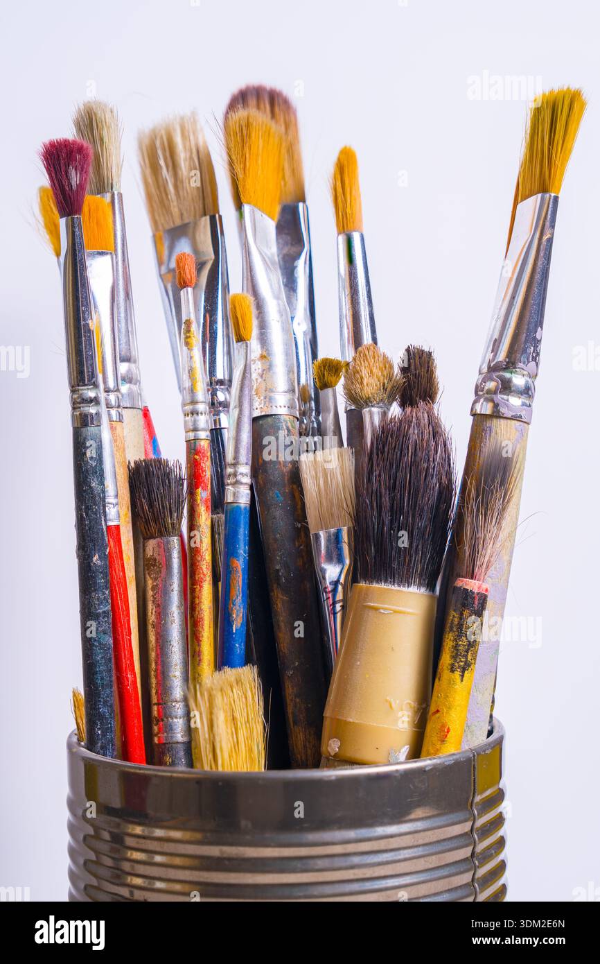 Une collection de divers pinceaux est montrée debout sur un fond clair. Ces pinceaux sont utilisés pour la peinture et l'activité artistique Banque D'Images