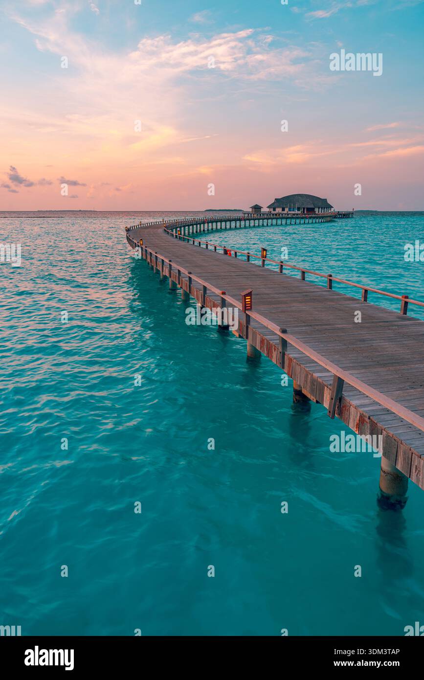 Coucher de soleil radieux sur l'océan Maldives avec jetée tropicale et vagues calmes sereines île paradisiaque ciel relaxant été fond de voyage de paysage marin Banque D'Images