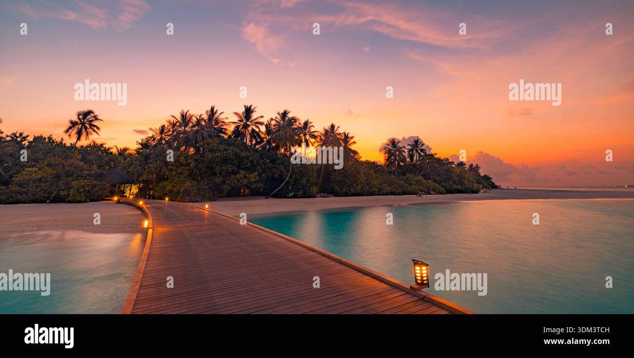 Romantique Maldives coucher de soleil brillant sur la jetée tropicale et les palmiers à couper le souffle île d'été paradis Seascape coloré fond de voyage de ciel Banque D'Images