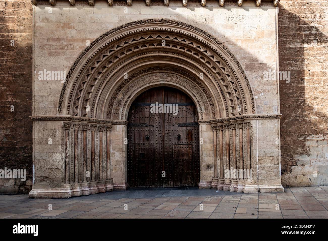 L'image capture la Puerta de la Almoina (porte de l'Alms), la plus ancienne entrée de la cathédrale de Valence en Espagne, présentant son design roman. Banque D'Images