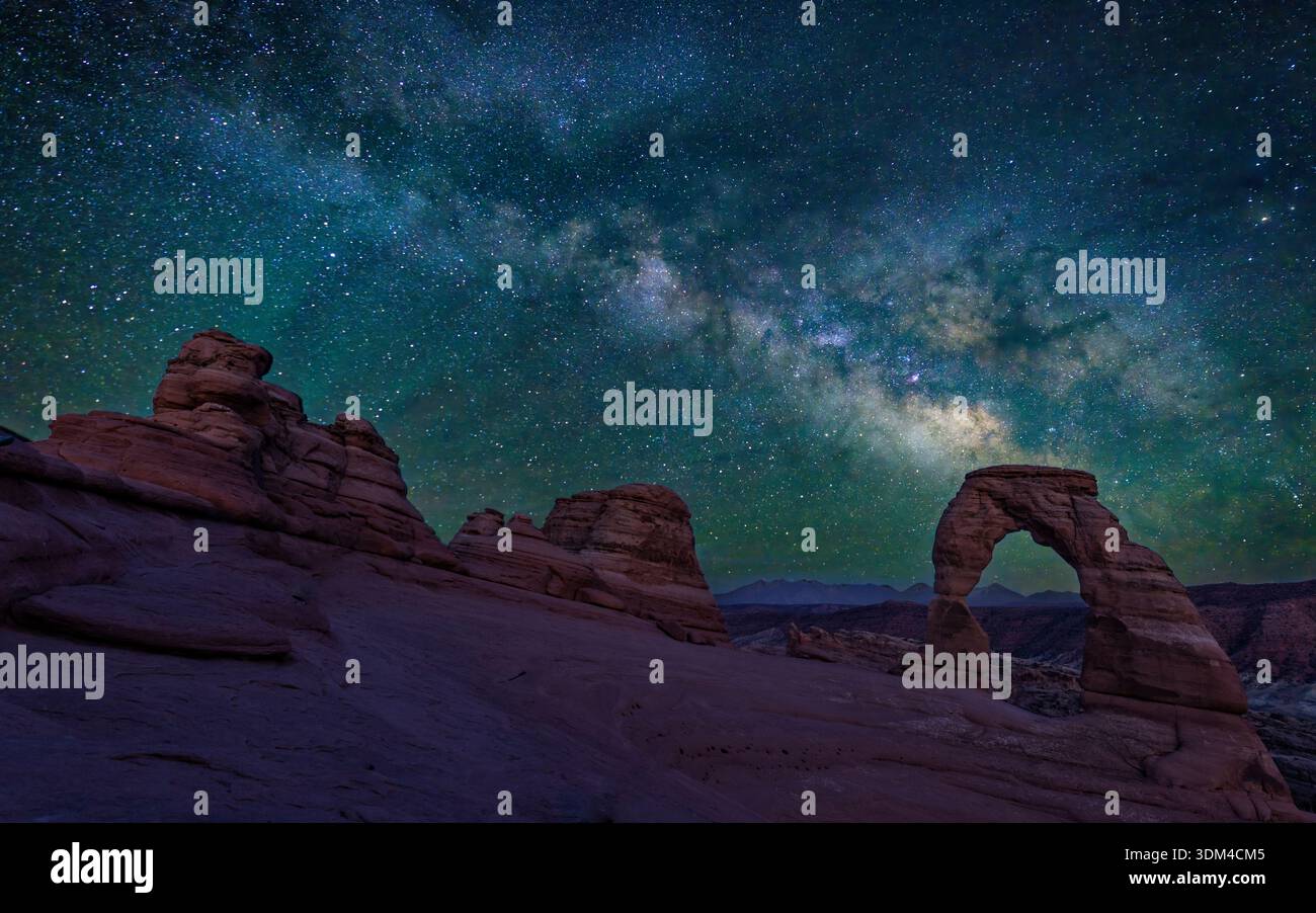 Une image d'astrophotographie mélangée de Delicate Arch à l'heure bleue, avec une seule image du ciel de la voie lactée, dans le parc national d'Arches, Utah. Banque D'Images