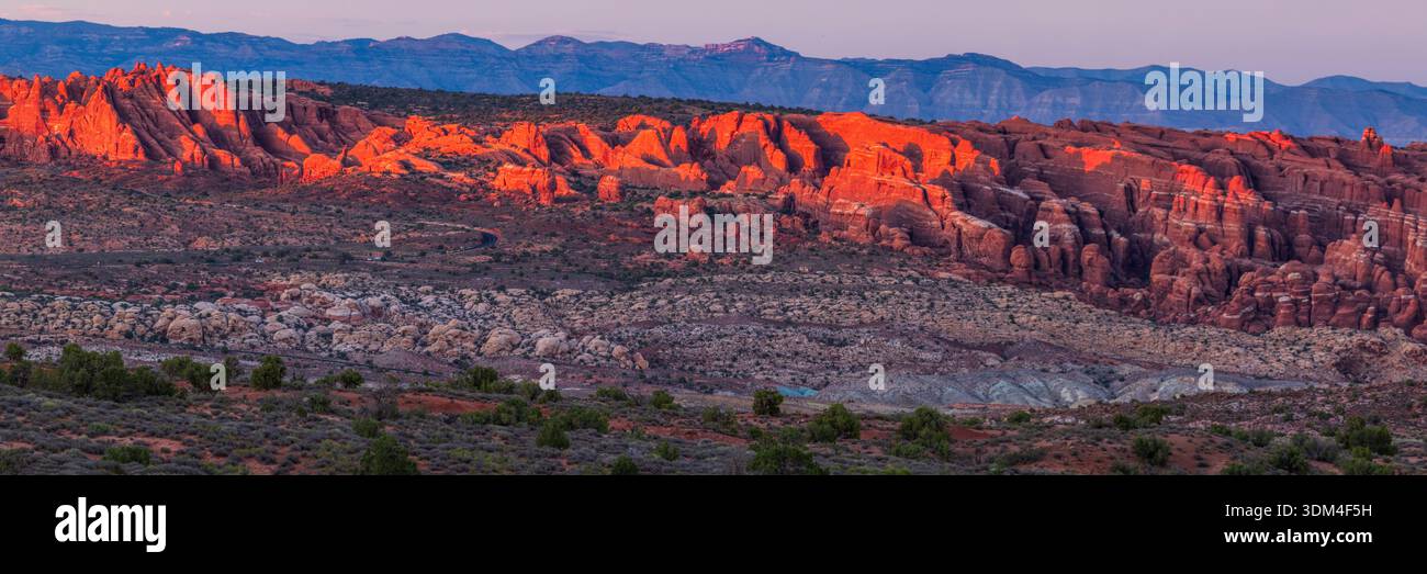 La lumière Golden Hour a frappé les ailerons du four au-dessus de la Salt Valley dans le parc national d'Arches, Moab, Utah. Banque D'Images