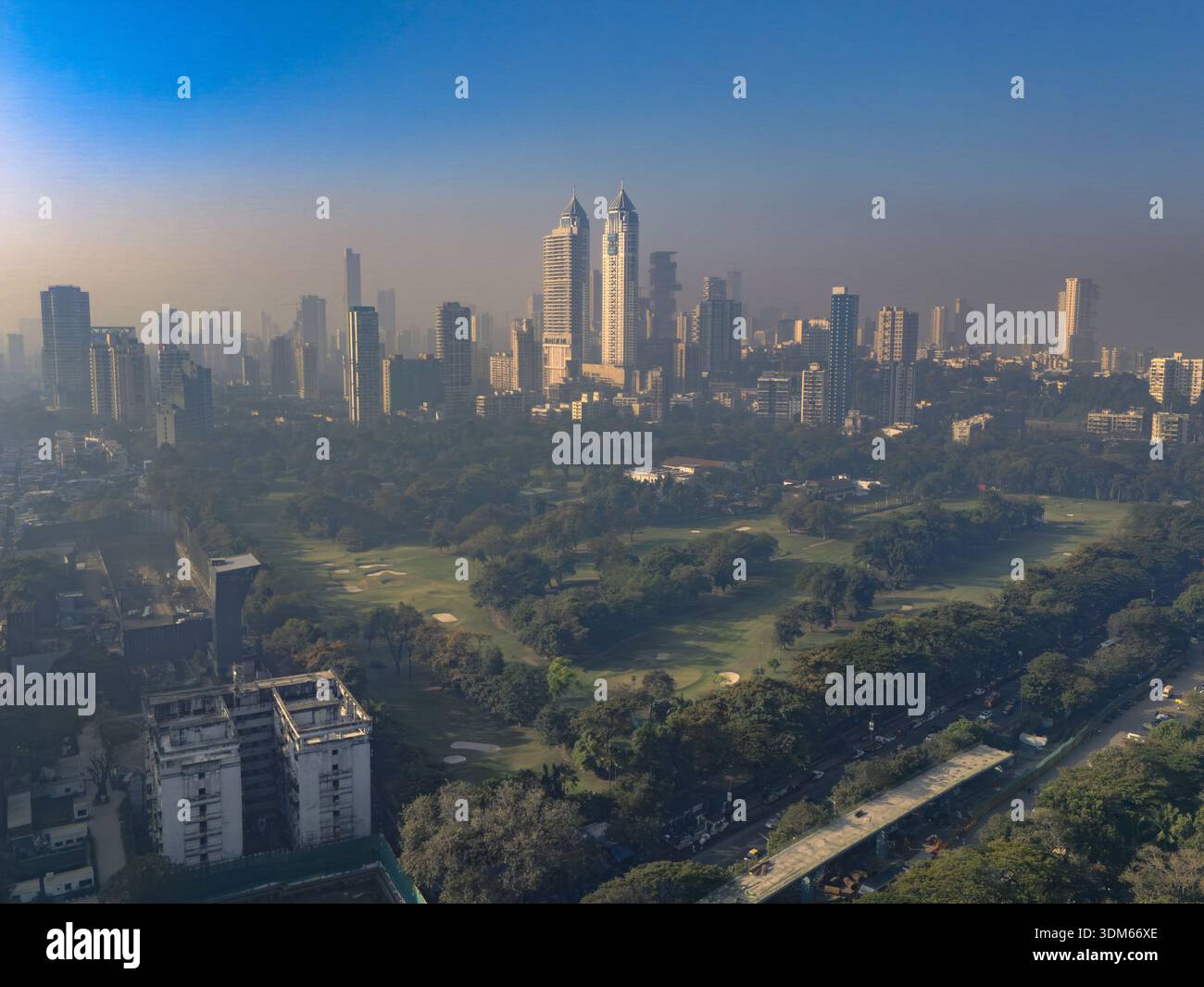 Mumbai, Inde - 16 janvier 2026 : vue aérienne de la ville s'élevant au-dessus d'espaces verts luxuriants, une symphonie de béton et de nature sous un ciel brumeux. Banque D'Images