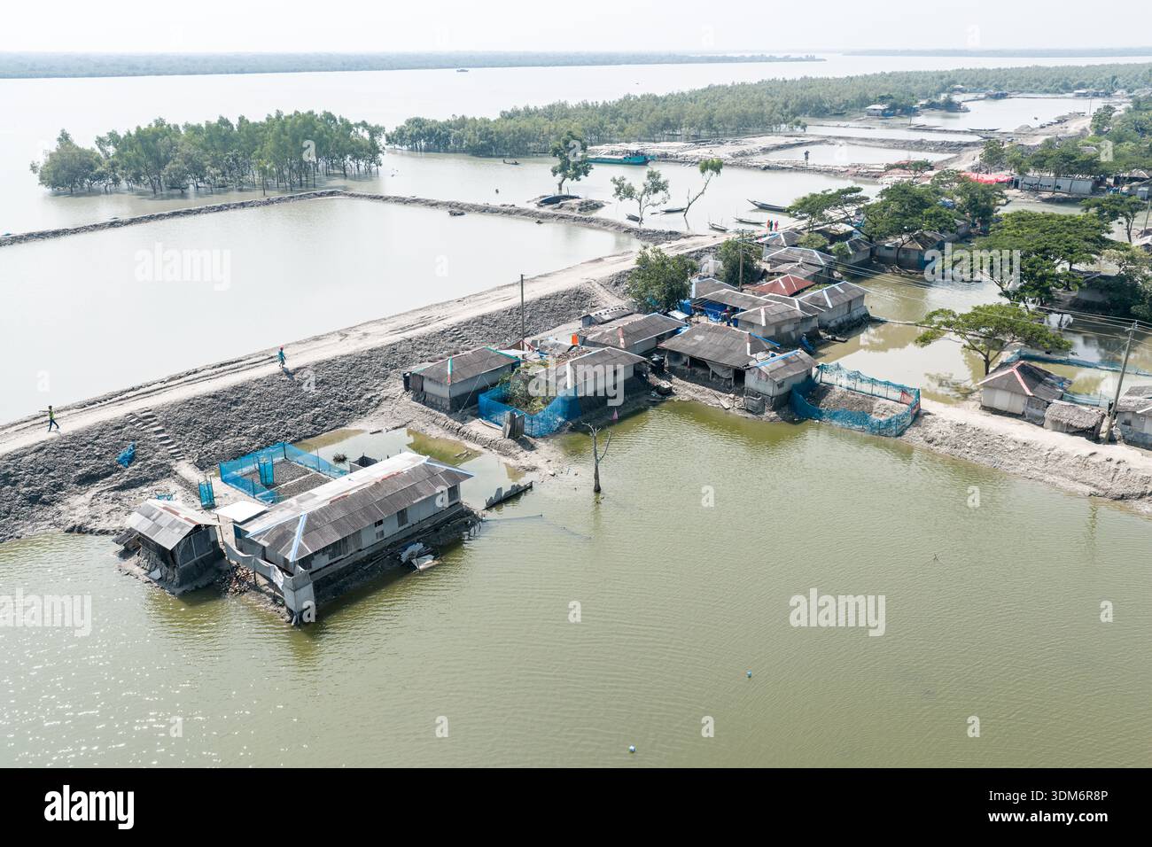 Satkhira, Bangladesh - 20 octobre 2025 : vue aérienne des maisons et des remblais entourés par les eaux de crue, où les tons discrets des habitations rencontrent le sh Banque D'Images