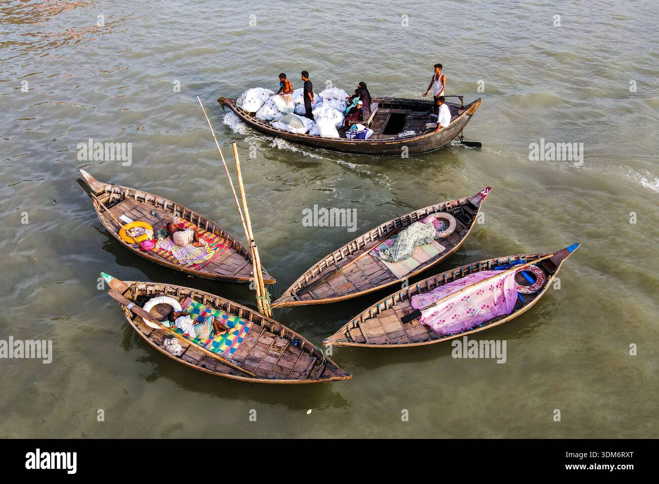Dhaka, Bangladesh - 31 août 2024 : vue aérienne de petits bateaux de pêche regroupés, leur contenu coloré contrastant avec les eaux boueuses o Banque D'Images