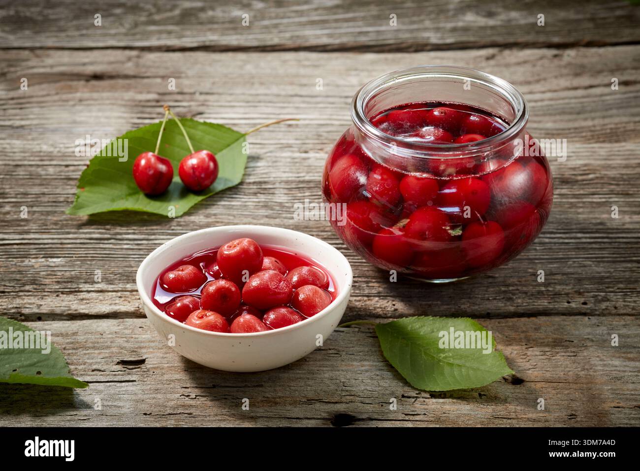 Cerises en conserve maison sur une table en bois. Allemagne Banque D'Images