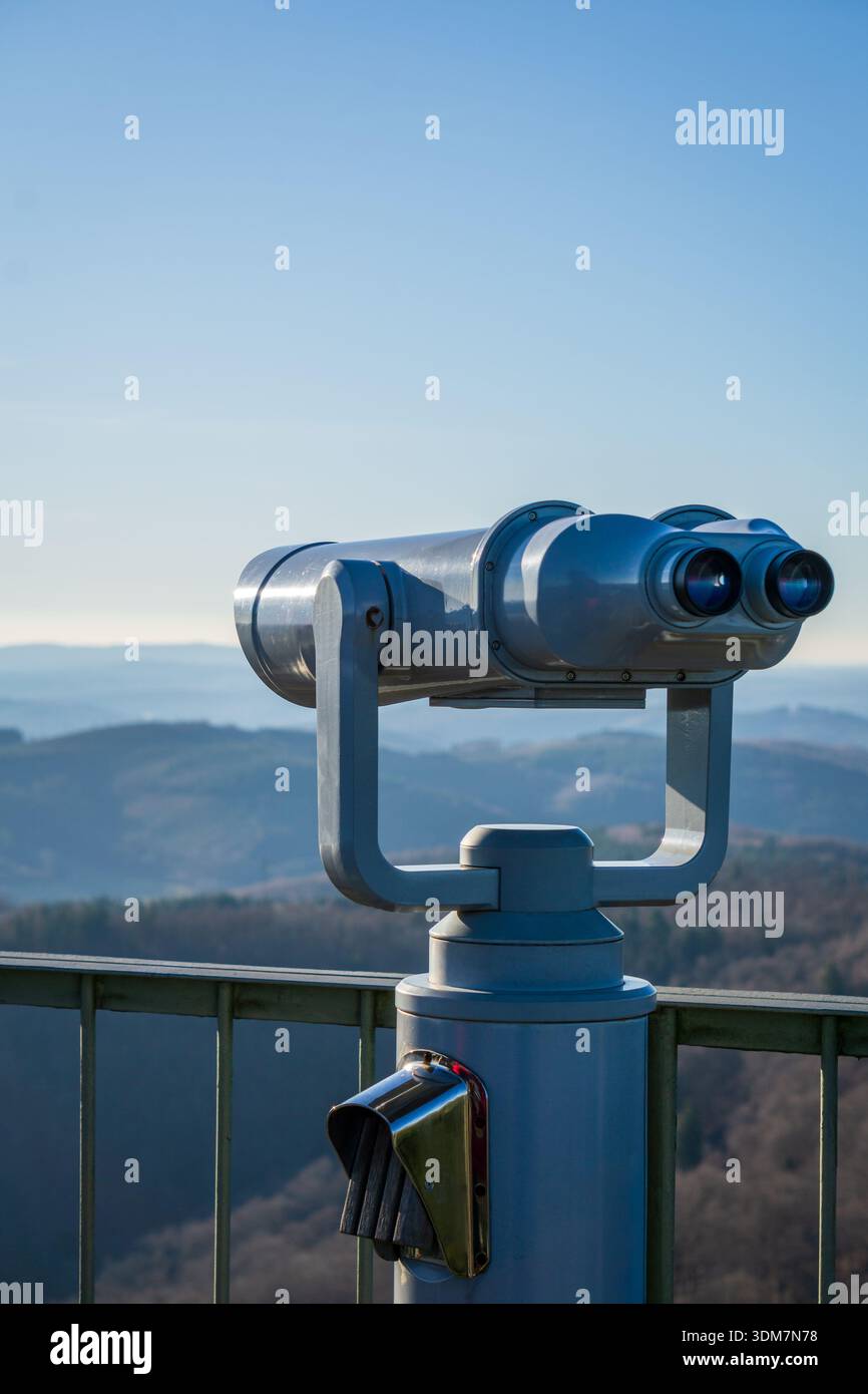 Des jumelles d'observation publique se dressent sur une terrasse d'observation surplombant des collines et des vallées lointaines. Banque D'Images