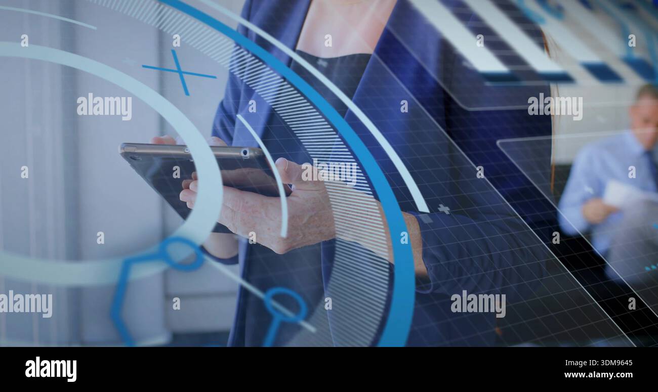 Tenant la femme dans le blazer marine interagissant avec la tablette au bureau, l'homme lisant des documents, les superpositions HUD Banque D'Images