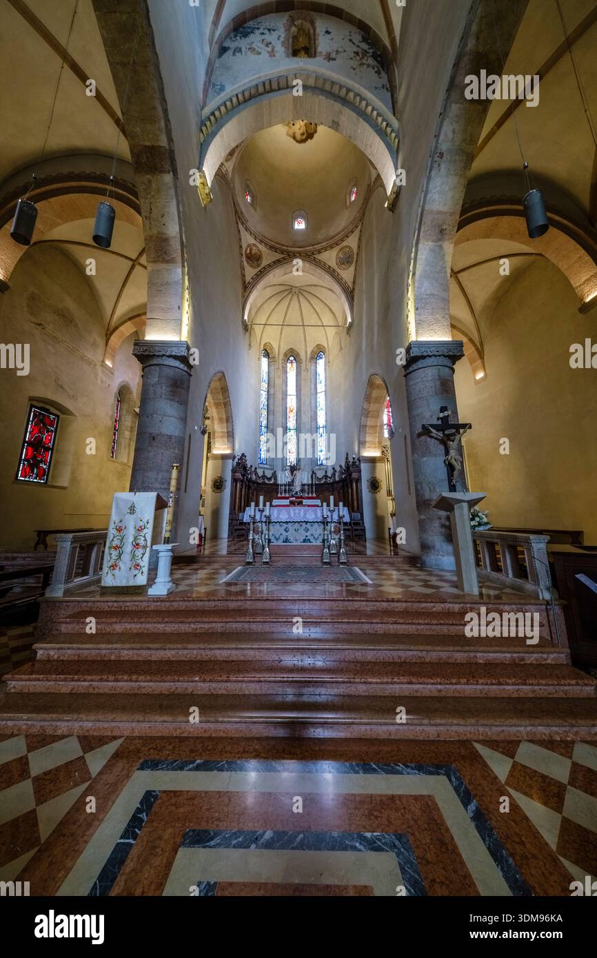 Vue sur l'autel et le chœur de l'église Duomo di Santa Maria Assunta avec des marches en pierre, des colonnes et des vitraux au loin. Banque D'Images