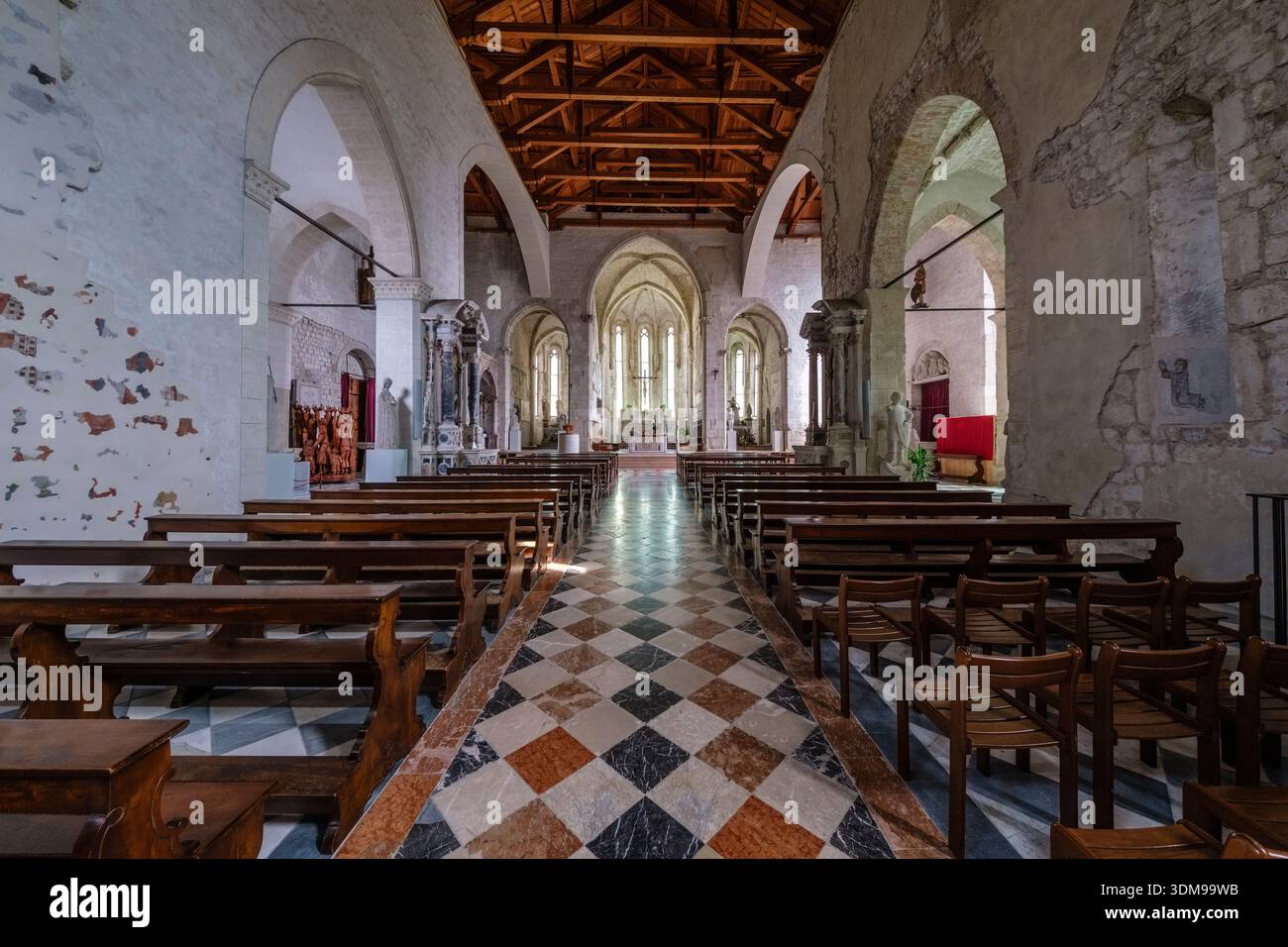 La nef de l'église Cathédrale de Saint André avec des colonnes de pierre et des arches. Un grand crucifix en bois pend au plafond. Banque D'Images