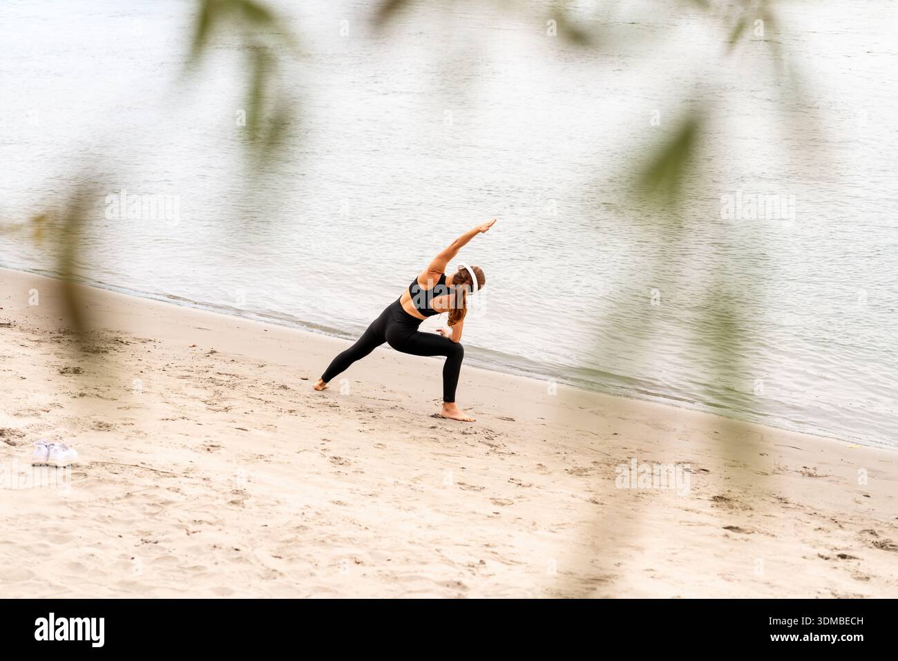 Femme en forme faisant de l'exercice de yoga par la rivière en saison d'automne. Banque D'Images