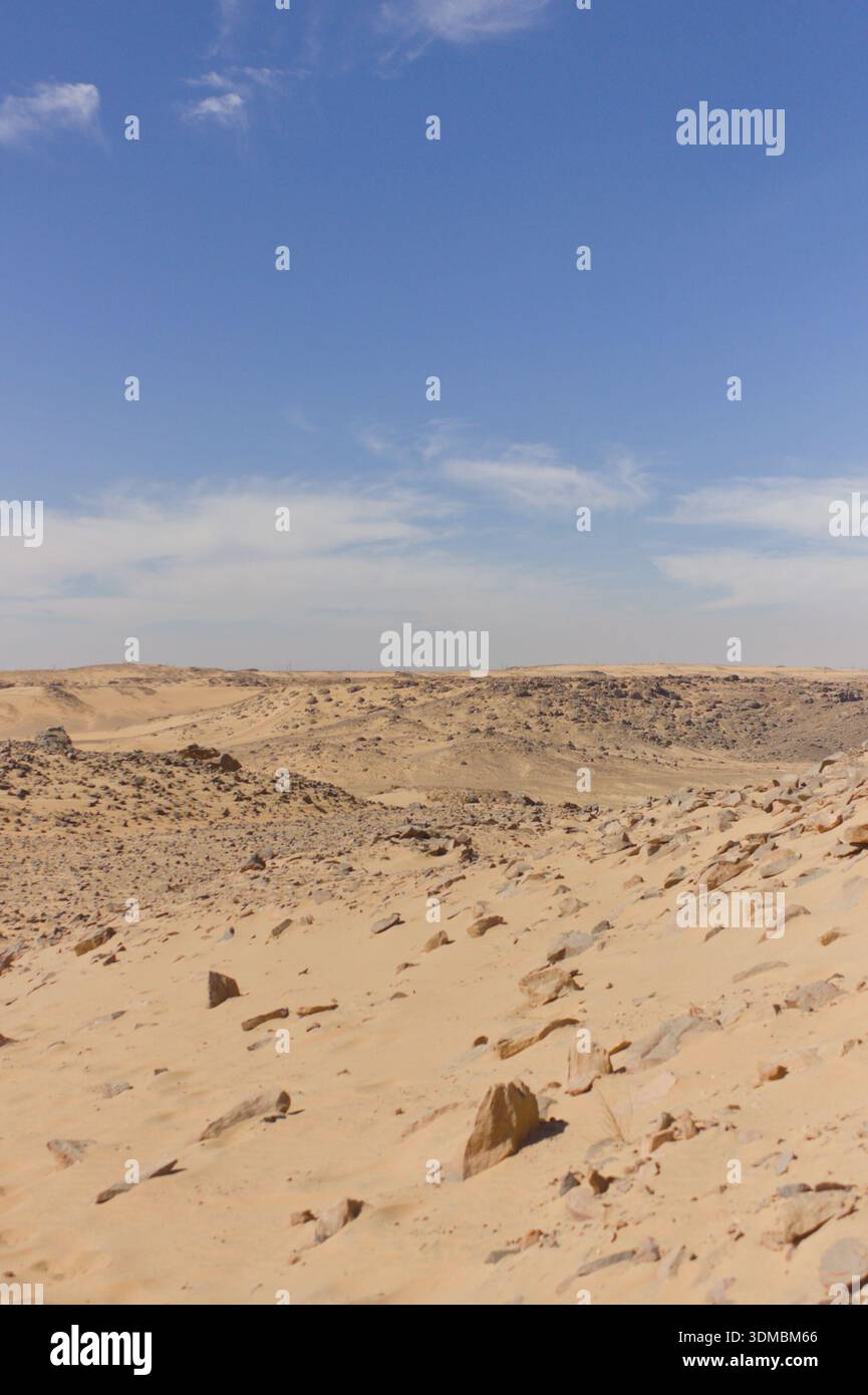 Paysage désertique rocheux avec des dunes de sable et un large ciel bleu Banque D'Images