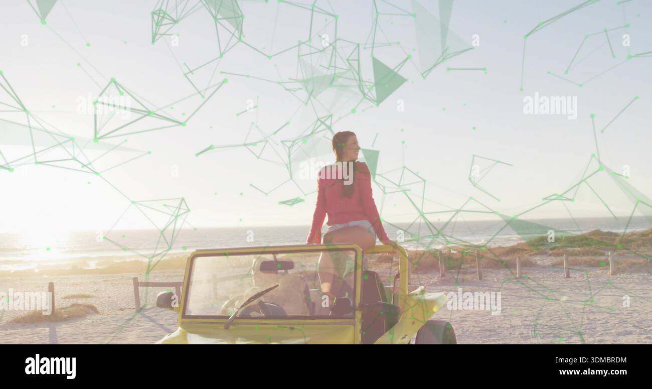 Femme regardant portant un haut rouge et un short blanc à la plage avec buggy jaune et recouvrement vert Banque D'Images