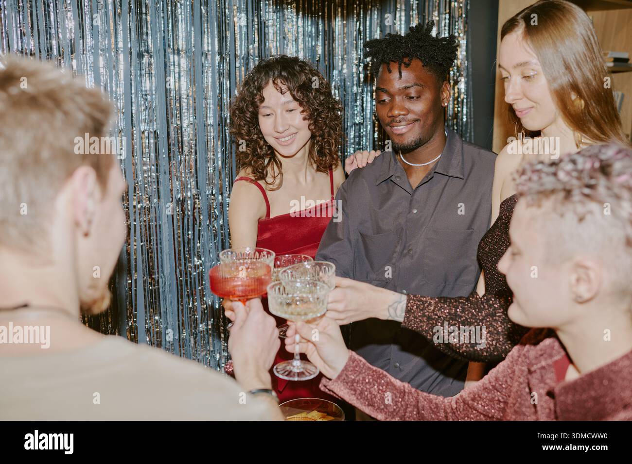 Groupe de jeunes amis multiethniques célébrant ensemble à la fête Banque D'Images