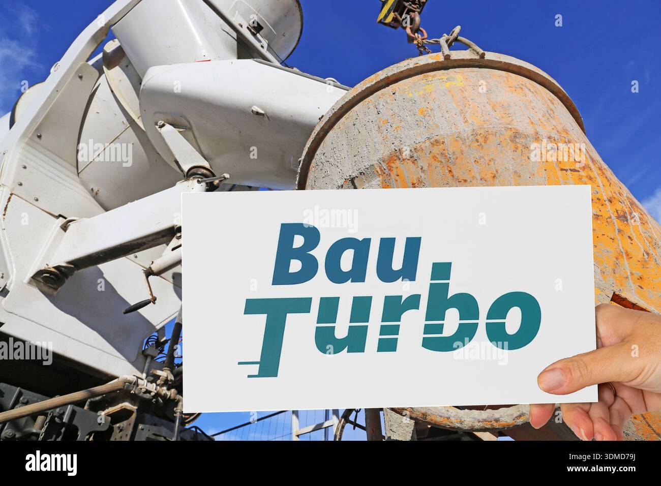 (Montage photo) signez avec le logo BAUTURBO devant un camion déchargeant du béton prêt à l'emploi Banque D'Images