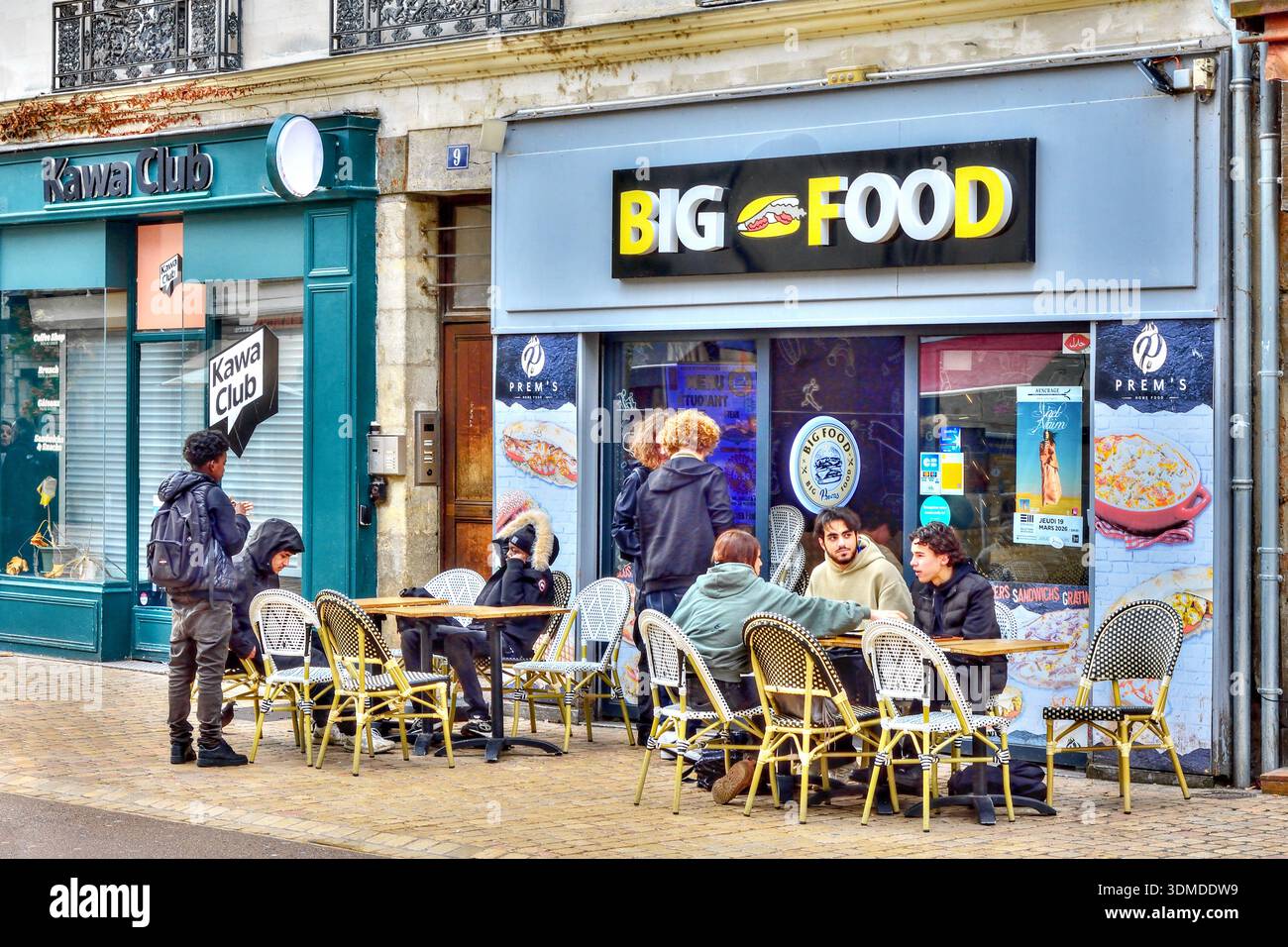 Des groupes d'étudiants à l'heure du déjeuner se sont assis devant un restaurant de restauration rapide 'Big Food' - Tours, Indre-et-Loire (37), France. Banque D'Images