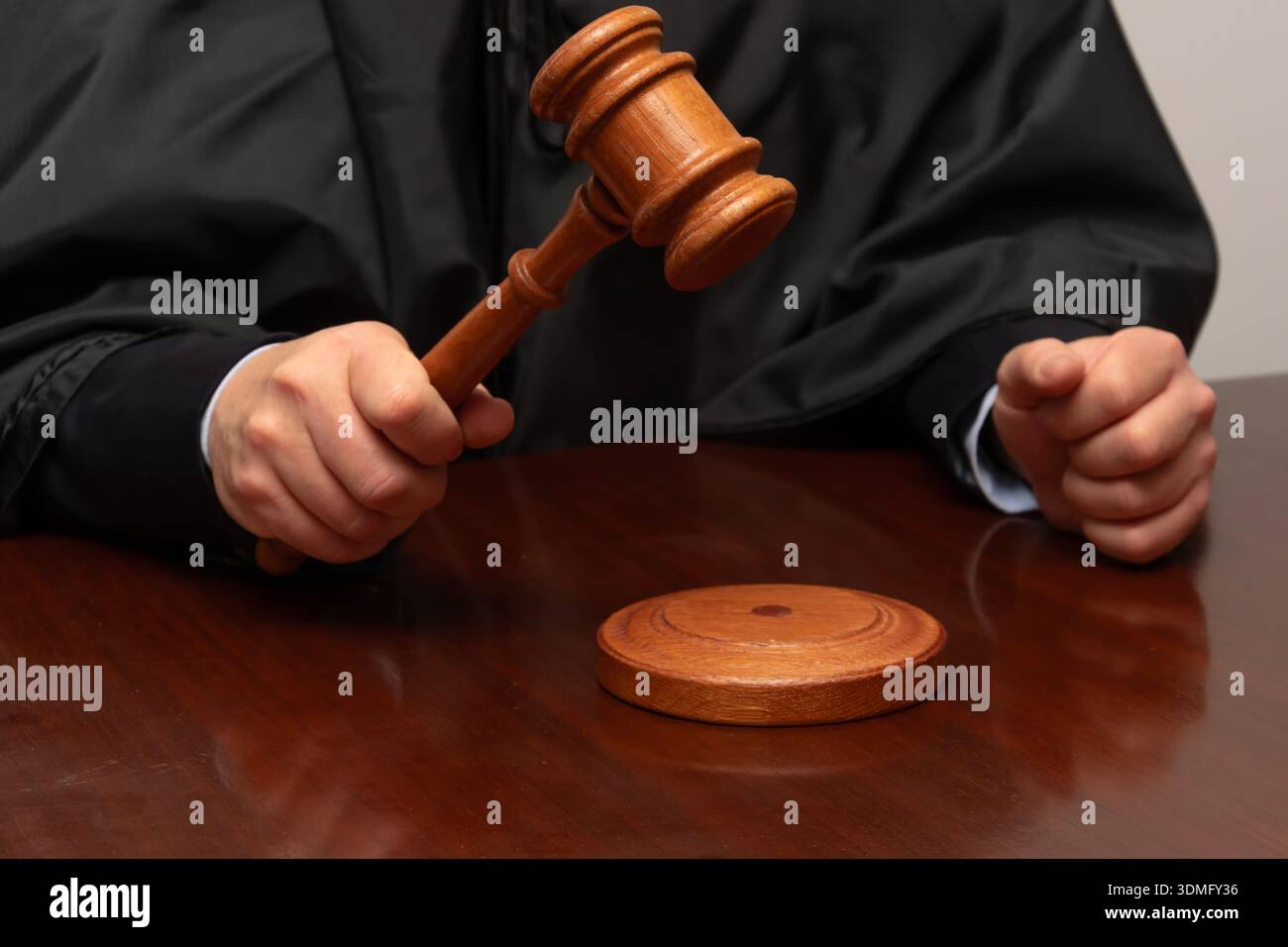Juge Hand avec un marteau en bois surélevé au-dessus de la table de la salle d'audience pendant la session Banque D'Images