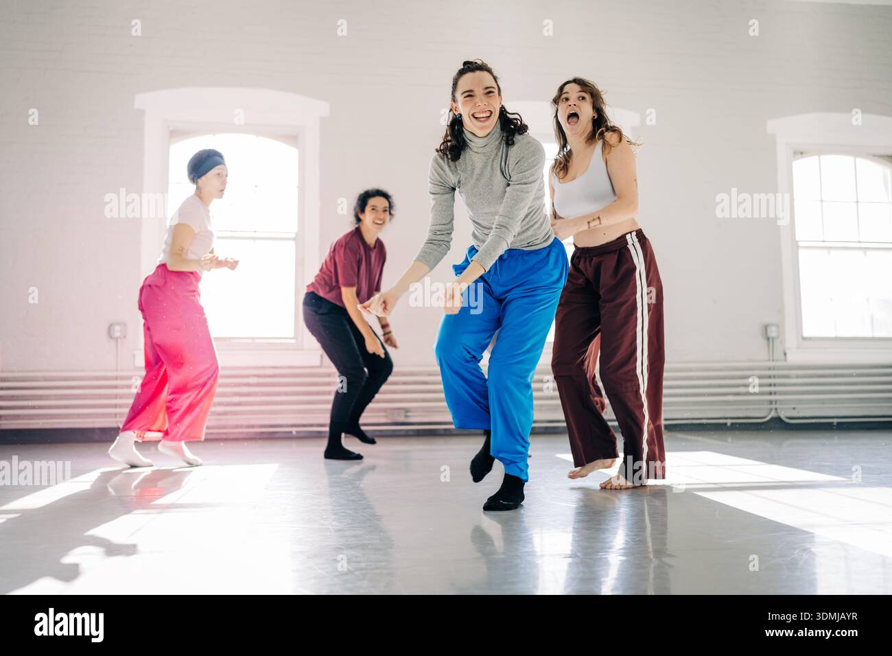 Groupe de femmes dansant ensemble dans un studio lumineux Banque D'Images